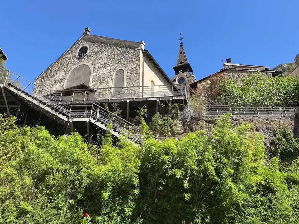 Une église de pierre perchée sur le rocher, desservie par des passerelles